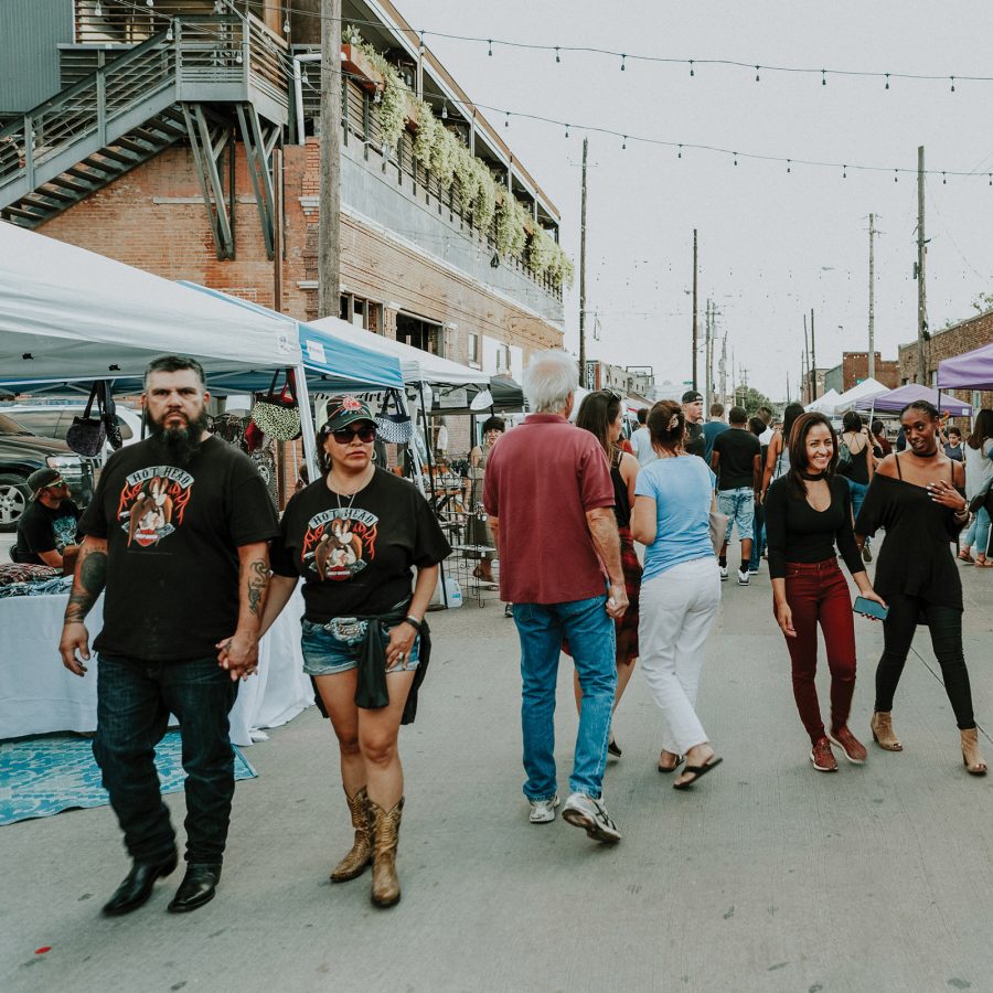Pedestrians walk along a street in the Deep Ellum neighbourhood in Dallas during the day.