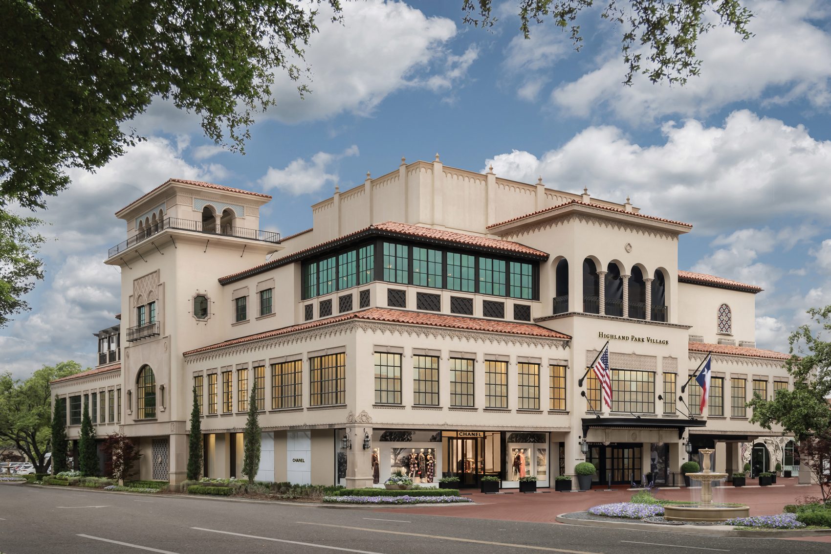 The exterior of Highland Park Village is a multilevel cream-coloured building with square panelled-windows.
