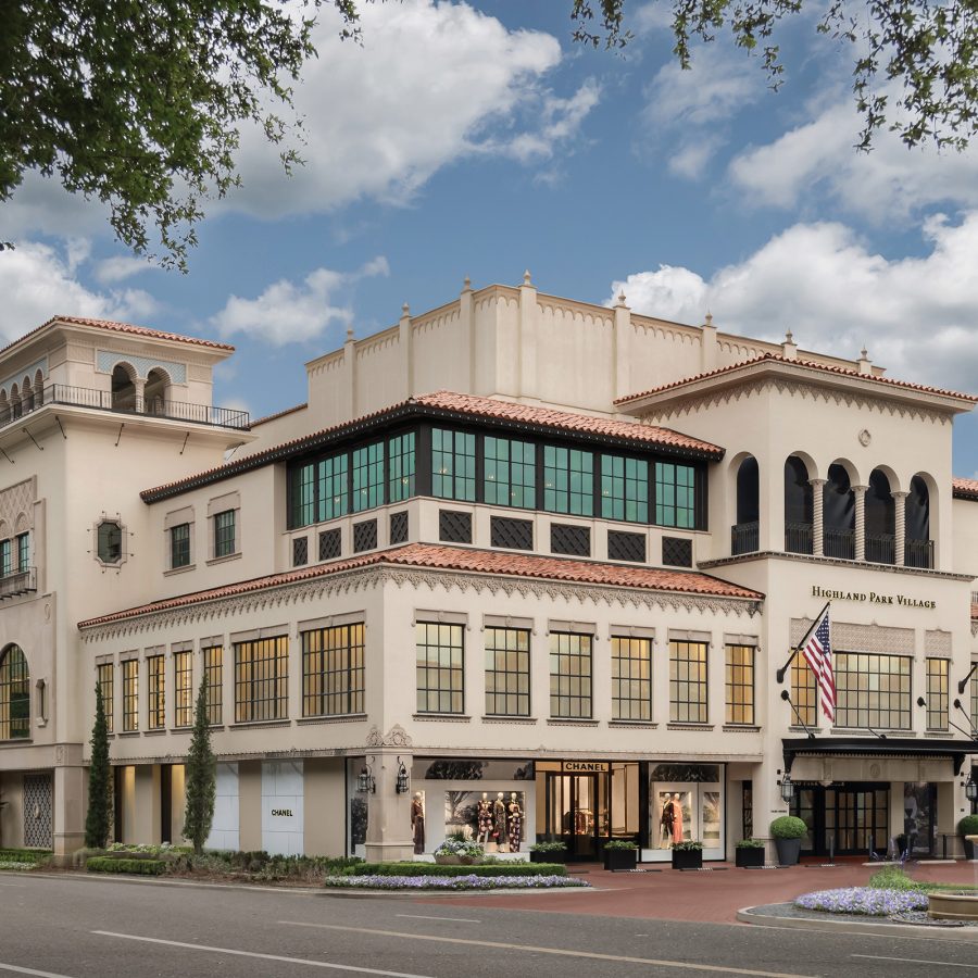 The exterior of Highland Park Village is a multilevel cream-coloured building with square panelled-windows.
