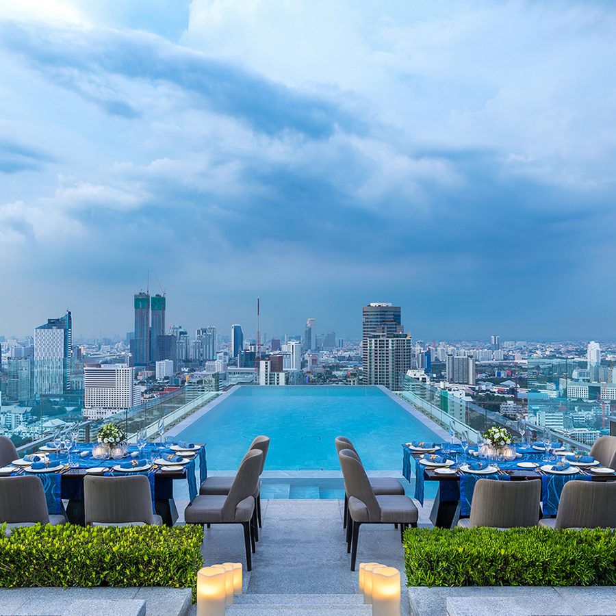 Wide shot pool view from 137 Pillars Suites & Residences, Bangkok, with the city in the background. 