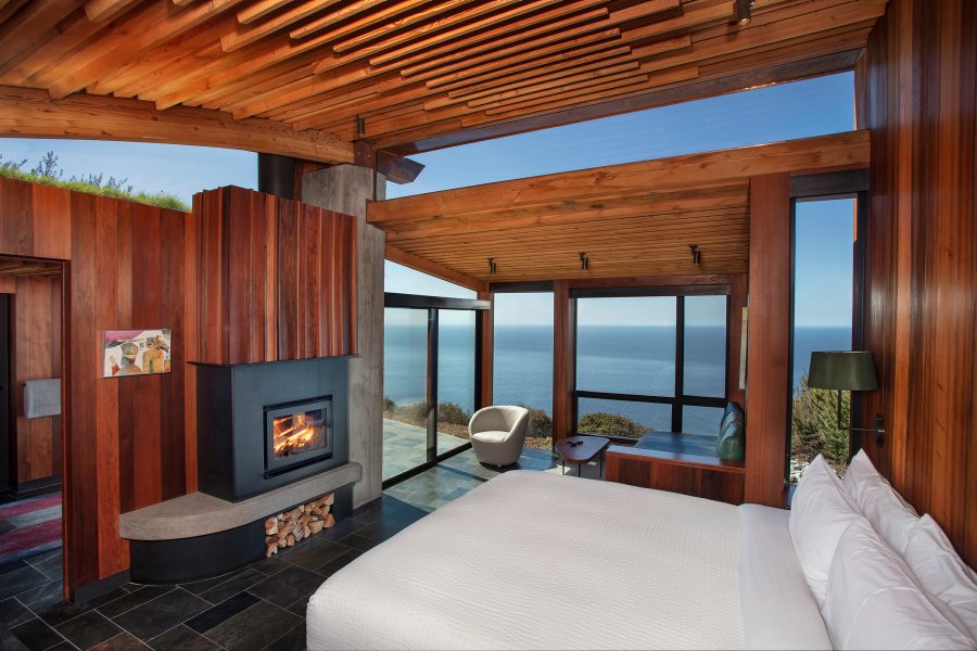 Wooden style decor and bed in a bedroom at Post Ranch Inn, California, USA.