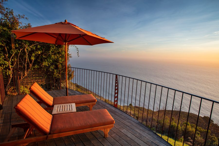 A balcony with sunbeds and an umbrella from Post Ranch Inn, California, USA. 