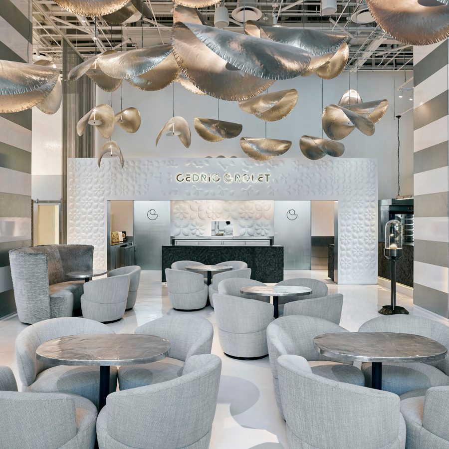 Cédric Grolet’s Parisian patisserie filled with grey tables and chairs and a silver ceiling installation in COMO Metropolitan Singapore.