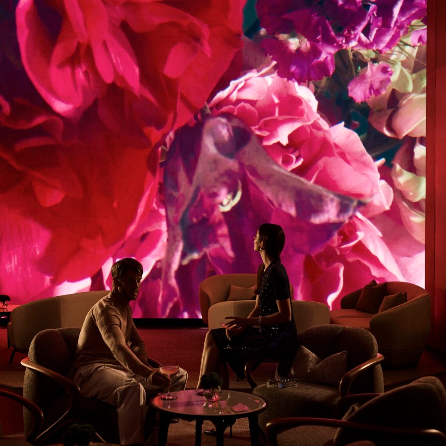 Vibrant pink and red floral digital art installation by Thomas Hilland named “Floral Dive” in lounge of COMO Metropolitan Singapore.