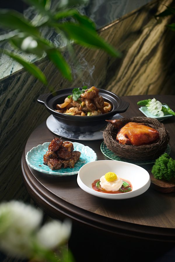 A stylish shot of various Shanghai dishes on a round table top next to the window served Shanghai Plus in Hong Kong.