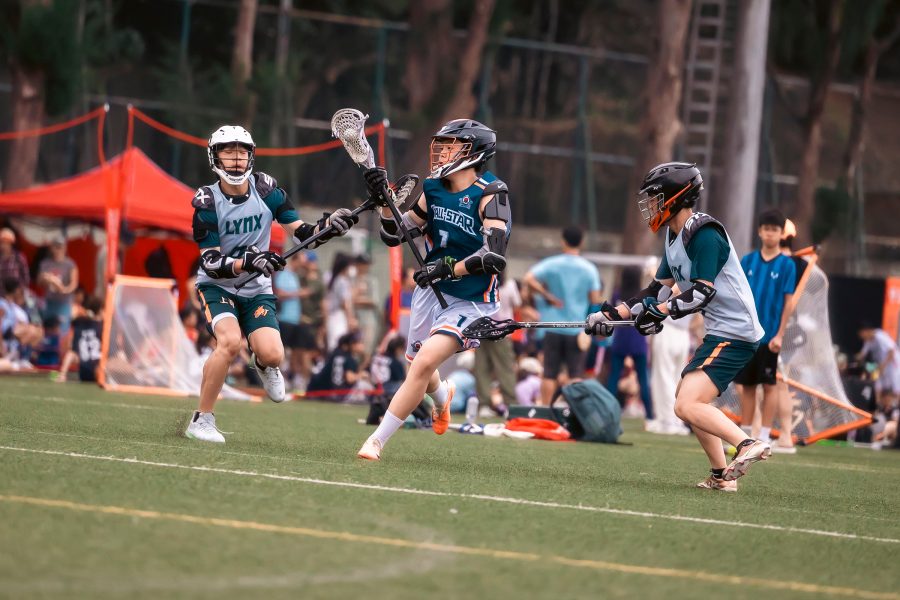 Lacrosse players running across the pitch at the Hong Kong Lacrosse Open.