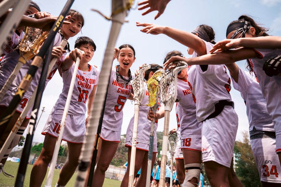 Players celebrating at the Hong Kong Lacrosse Open as a referee runs past. 