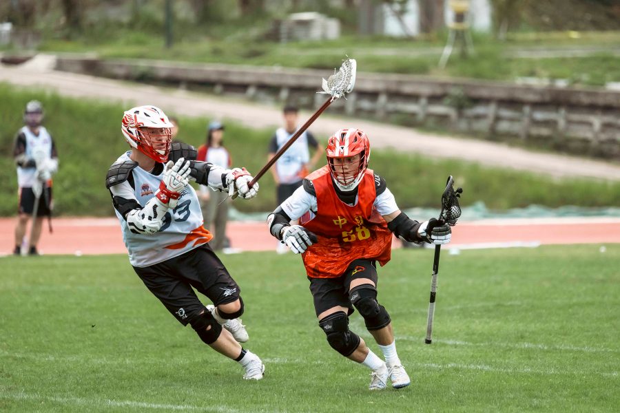 Two lacrosse players face off on a pitch at the Hong Kong Lacrosse Open.