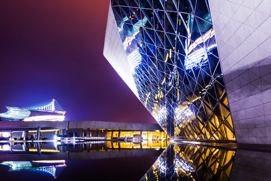 The futuristic stone and glass exterior of the Museum of Contemporary Art & Planning in Shenzhen, at night.