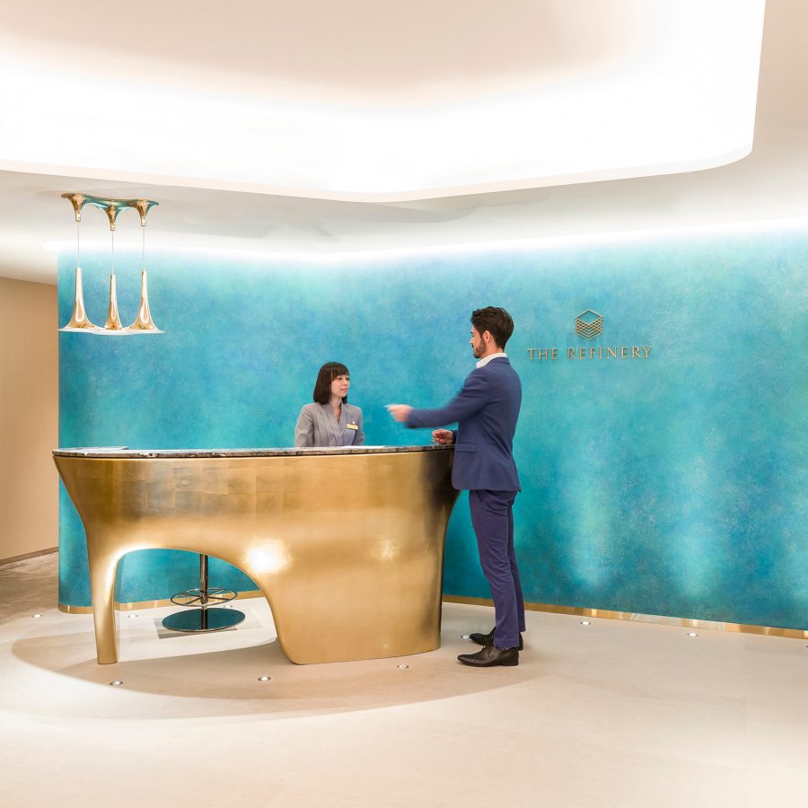 A female staff assisting a member at the reception in the main lobby of The Refinery private member’s club.