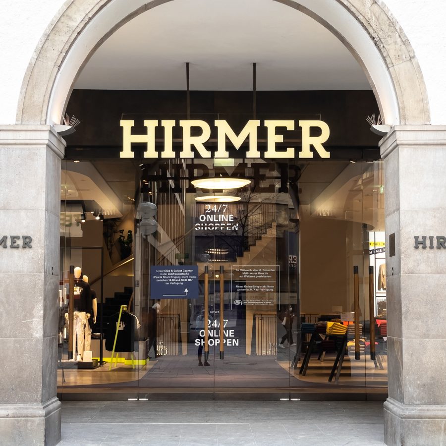 View of the Hirmer logo hanging over the store between two pillars.  