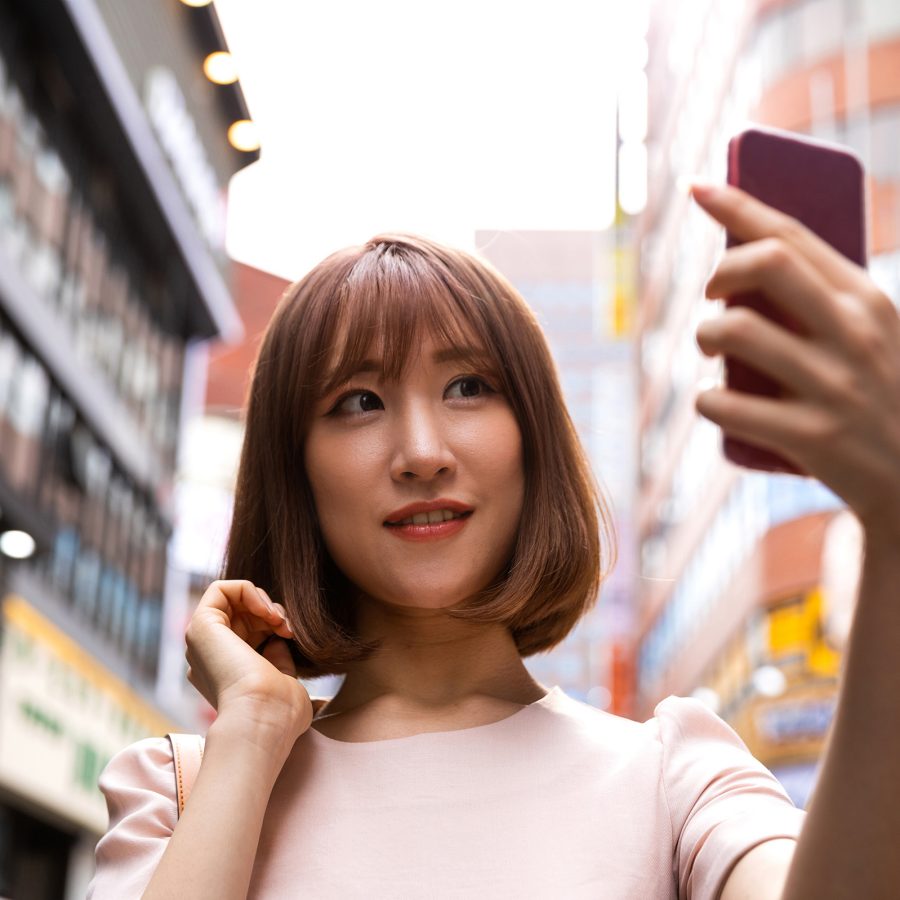 A woman taking a selfie on the street. 