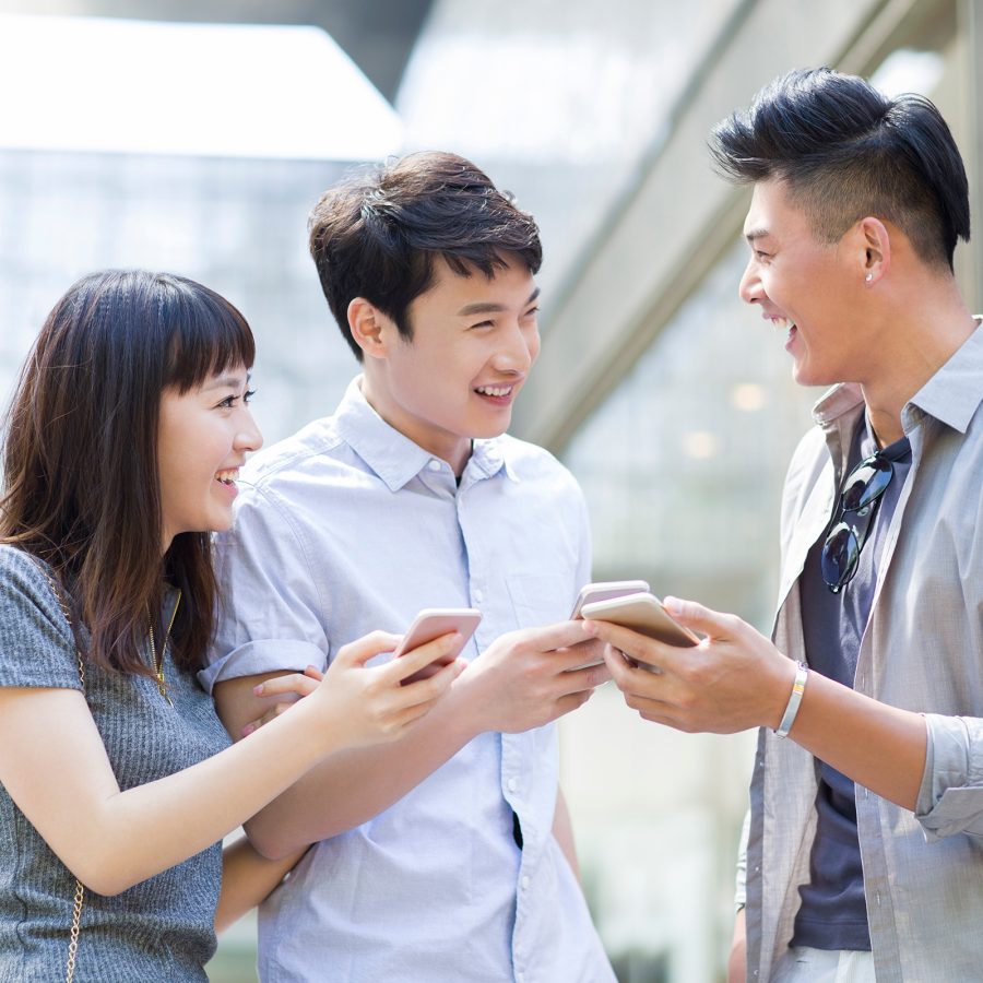 A group of people show the contents of their phone screens with each other as if connecting over WeChat.