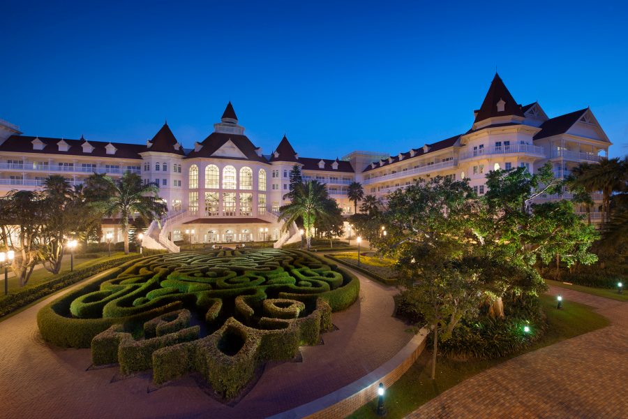 Exterior night time view of the Hong Kong Disneyland Hotel and its illuminated garden.