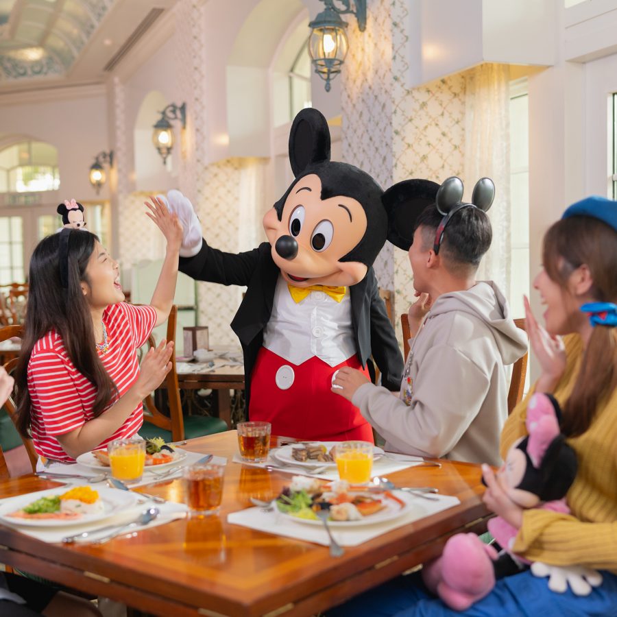 Mickey Mouse greets a table of Hong Kong Disneyland Hotel guests at breakfast.