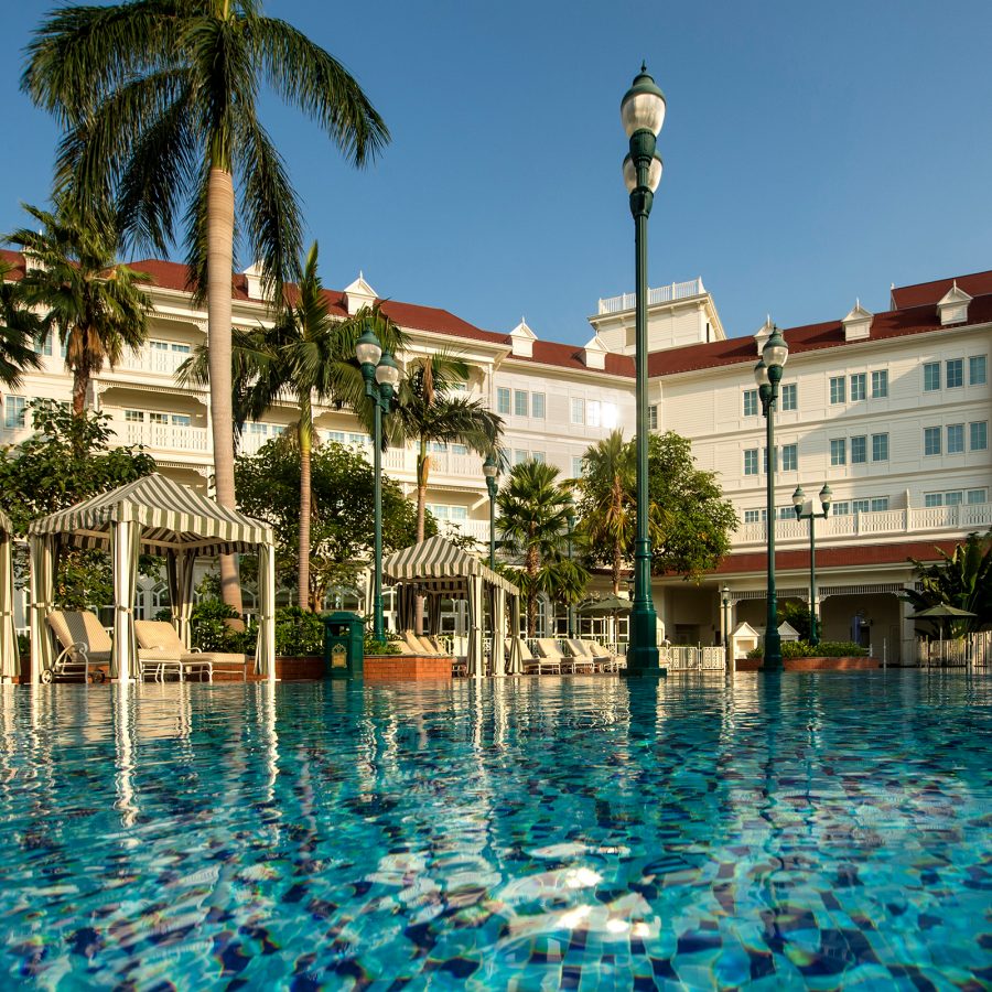 View of the swimming pool at Hong Kong Disneyland Hotel and white facade in the background. 
