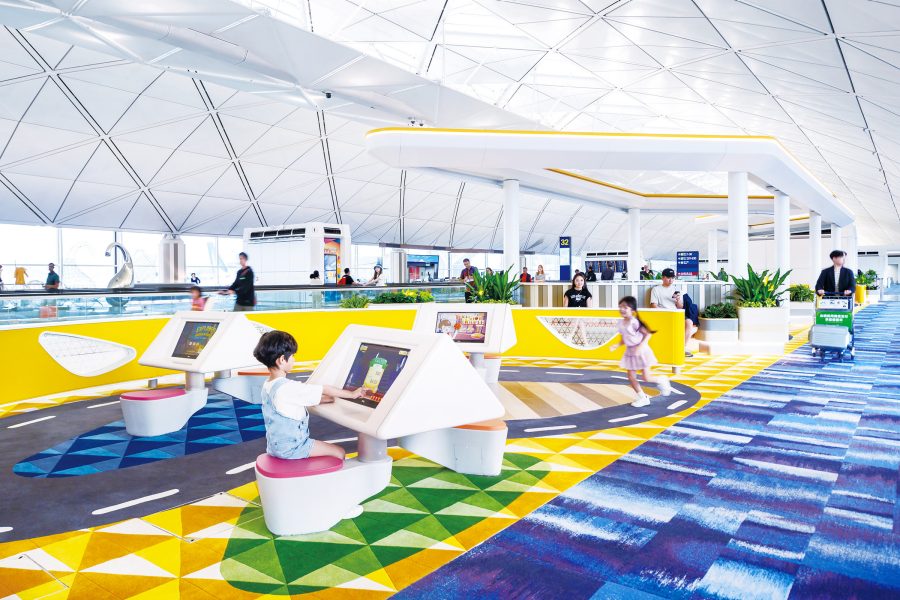 Children playing interactive games at colourful Buzz Zone inside Hong Kong International Airport .