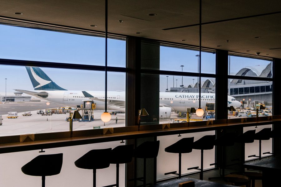 A Cathay Pacific lounge airside at Hong Kong International Airport with a Cathay Pacific aircraft seen through the windows.
