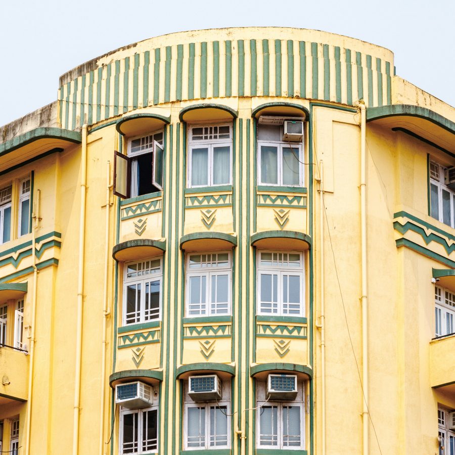 The yellow and green Art Deco façade of the Shiv Shanti Bhuvan, a residential building in Mumbai.