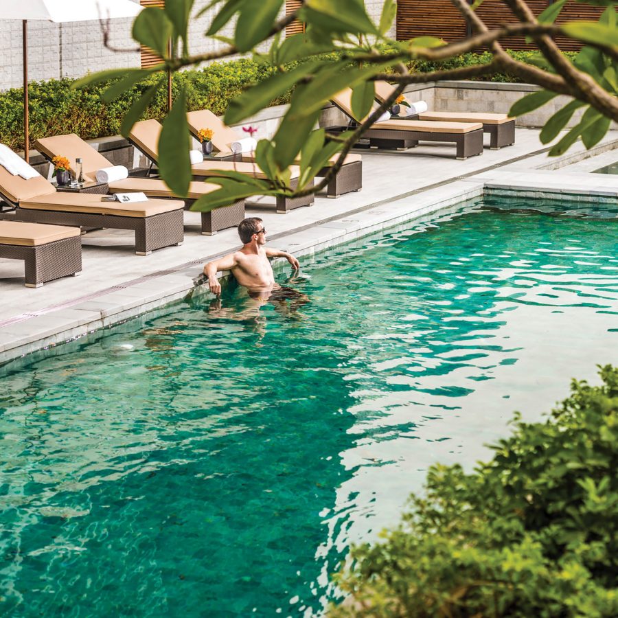 A view of a man relaxing at the outdoor swimming pool at Four Seasons Hotel Shenzhen, China.