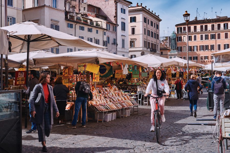 A man holds up a pizza from Bonci Pizzarium in Rome.