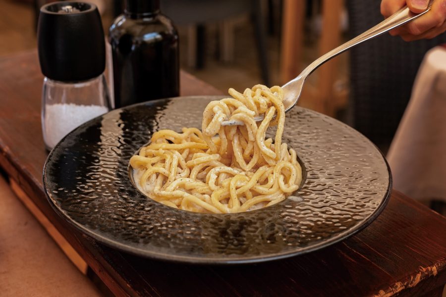 A diner holds up a forkful of spaghetti. 