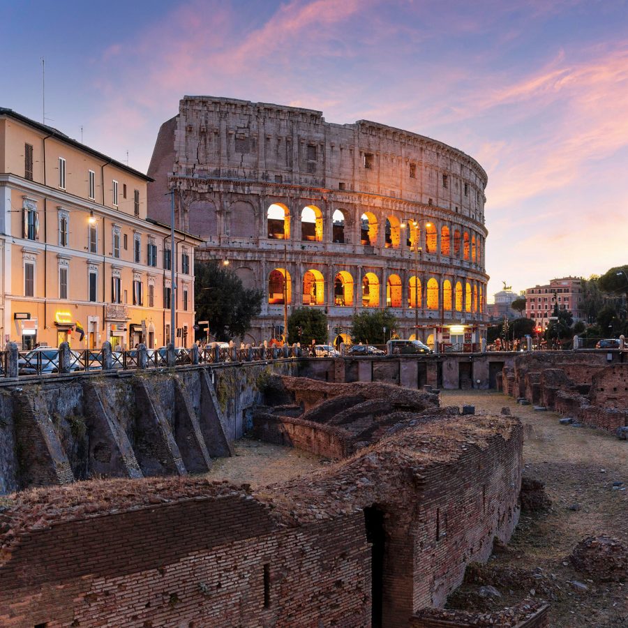 The Colosseum glows with light at dusk. 