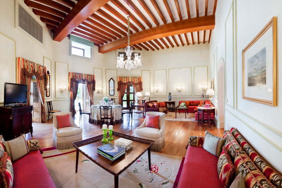 Colourful red furnishings and an exposed beam building in a room at Taj Falaknuma Palace in Hyderabad, India