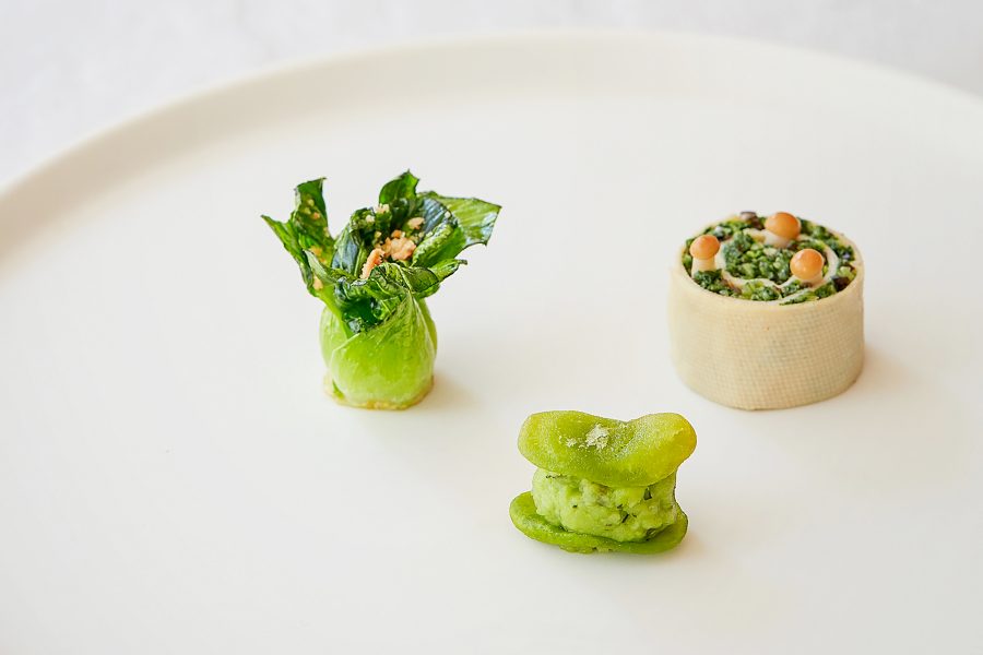 A closeup of a vegetarian dish featuring spring vegetables bok choy, snow pea and a rolled tart, served at Fu He Hui in Shanghai, China