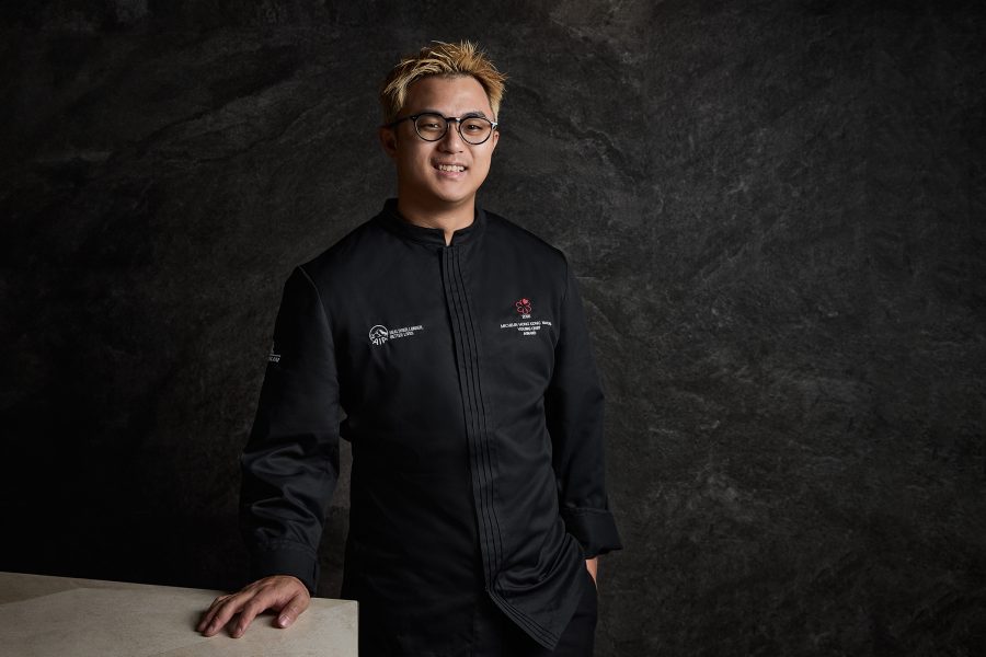 Headshot of Chef Frankie Wong from Hong Kong’s Ankôma smiling with one hand on a counter