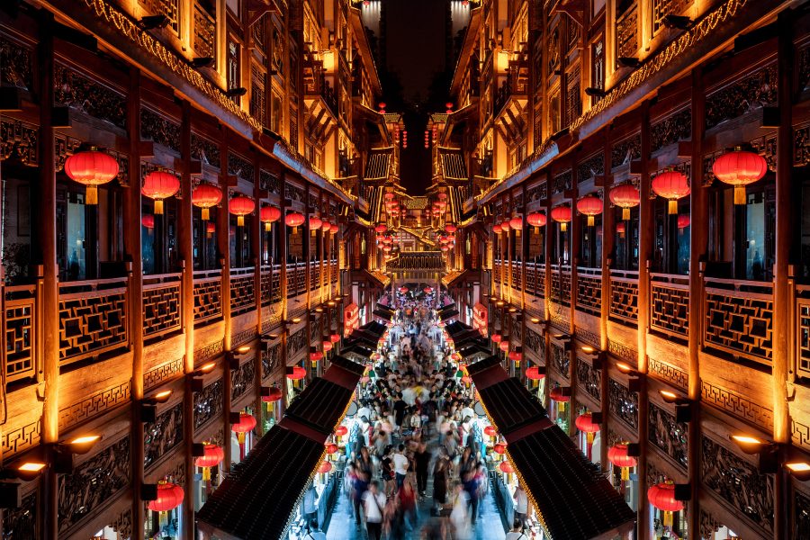 People walking in Hongya Cave, a 11-storey stilt-building complex lined with red lanterns, in Chongqing, China.