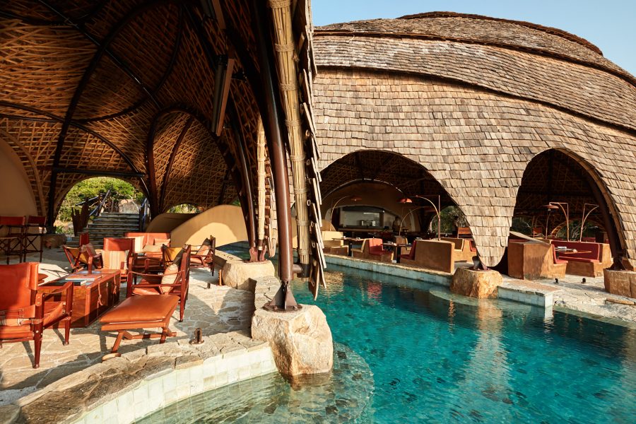 Lounge chairs and recliners ring a swimming pool in Wild Coast Tented Lodge in Yala, Sri Lanka