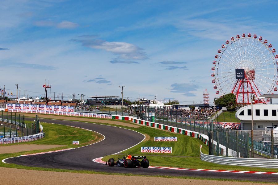 A car on a Formula One racetrack and a Ferris wheel in the distance in Suzuka City, Japan.