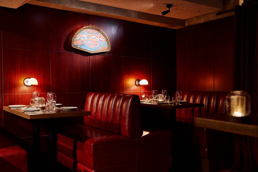 The interior of Bourke’s features dim lighting and deep mahogany booth seating.