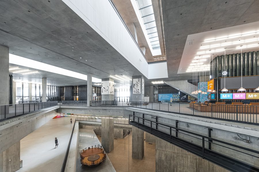 The interior of M+ features brutalist design details like large gray walls and empty floors.