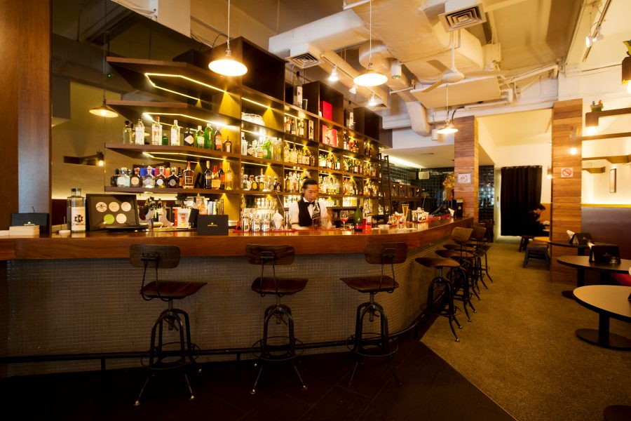 A bartender stands behind the counter at Jigger & Pony in Singapore