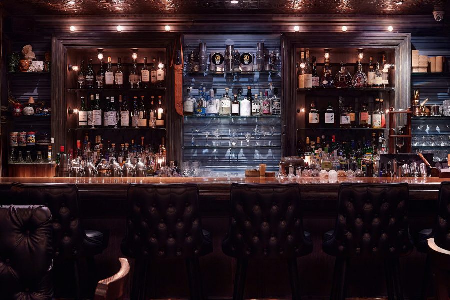 View of the dark wood and navy bar at Speak Low in Shanghai