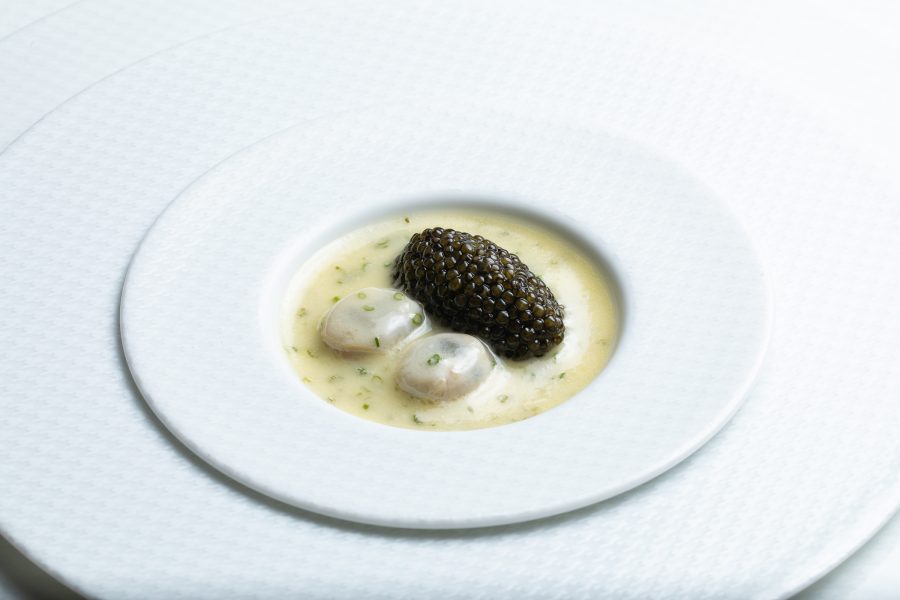 A white plate topped with caviar sitting in a cream-coloured sauce at The French Laundry in California