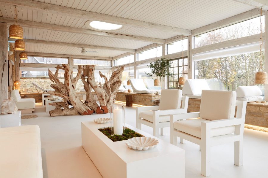 A tranquil white sitting area with a wooden installation at the Bamford Wellness Spa in The Cotswolds