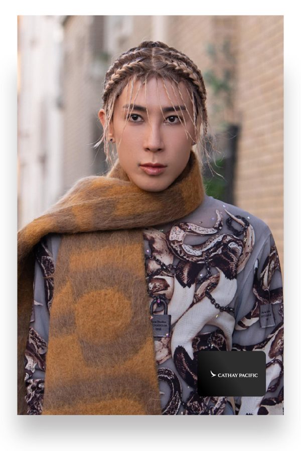 Fashion expert Mayao Ma poses wearing a large brown scarf and patterned top.