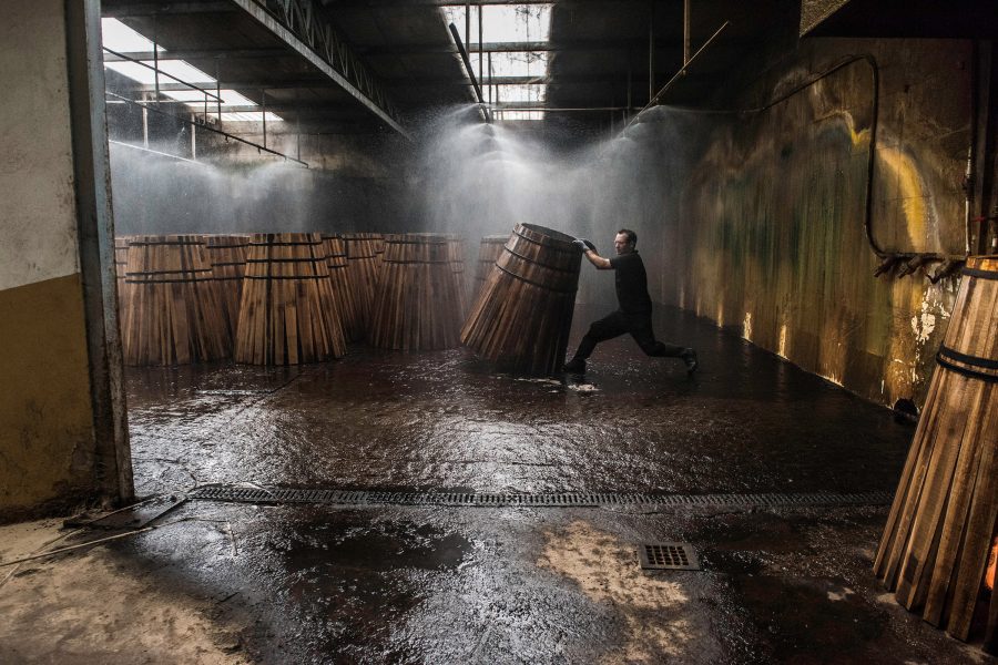 Man moves a wooden object in The Macallan Distillery.