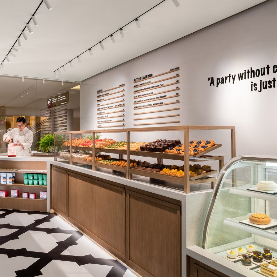 The interior of LMO Freshly Baked includes two rows of pastries on a shelf and a glass display.  