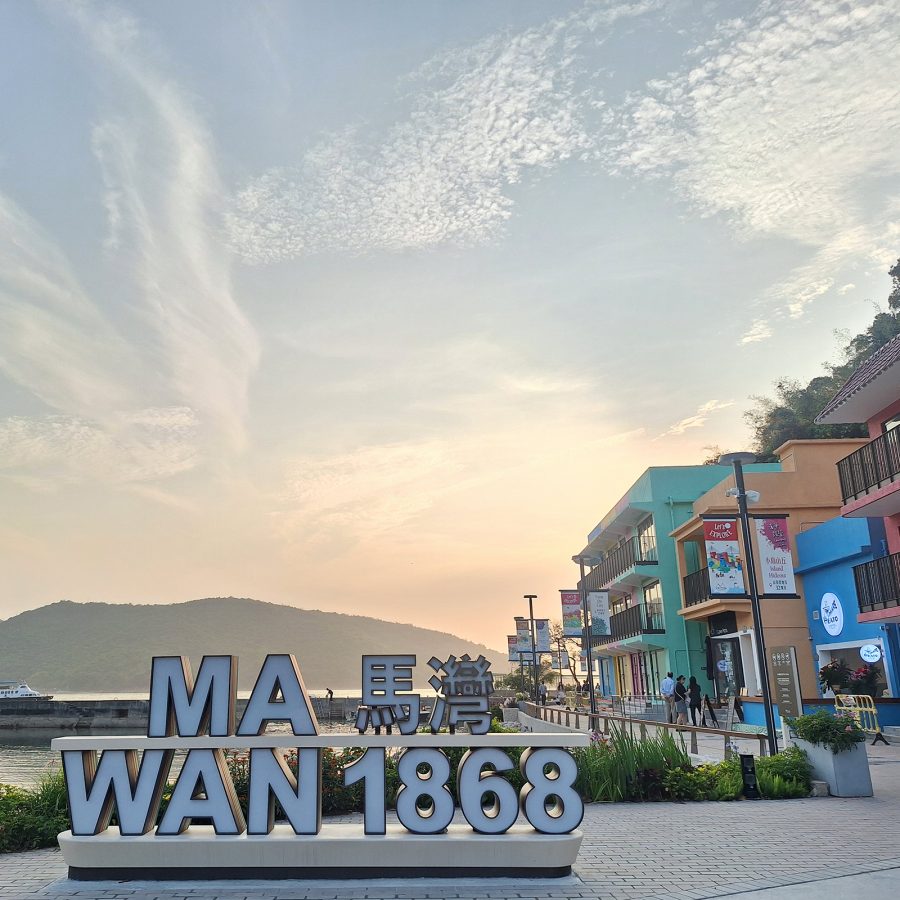A sign for Ma Wan 1868 against the horizon and mountain silhouettes.