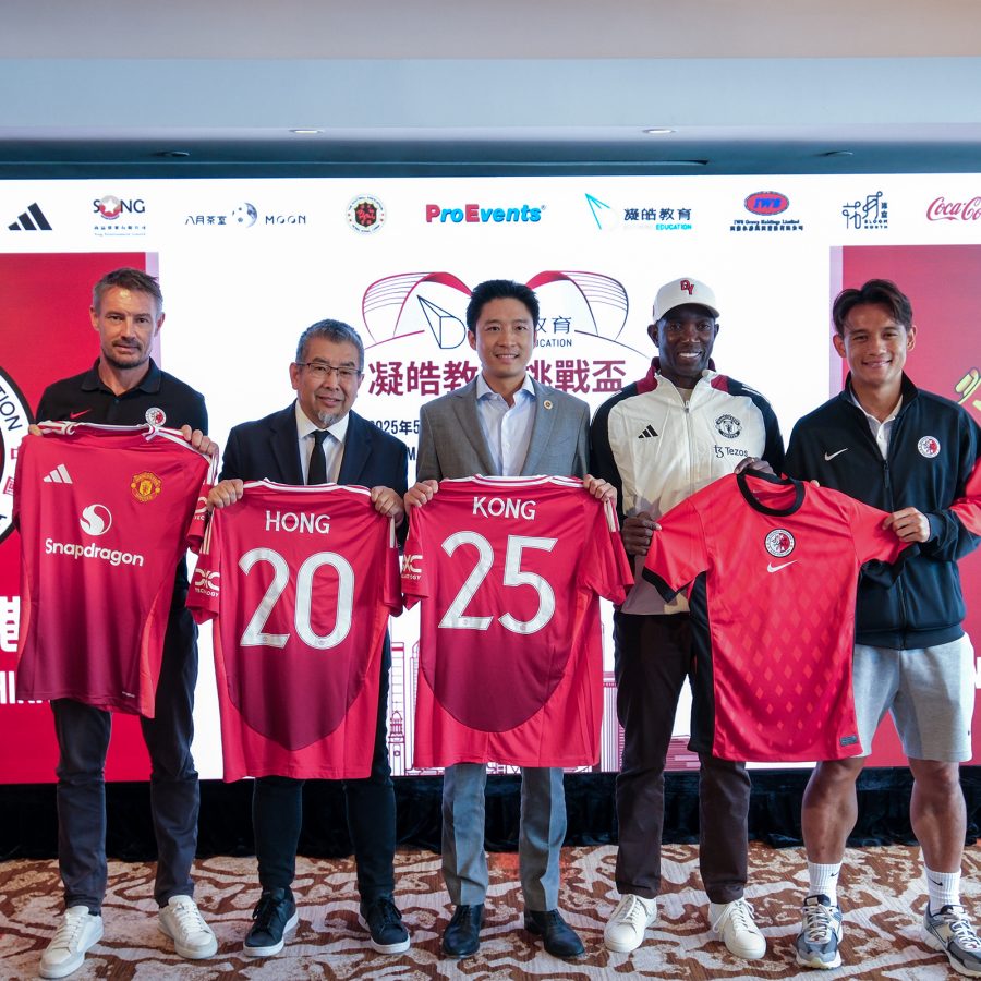 Former football player Dwight Yorke, members of the Hong Kong football association and more hold up Manchester United football shirts which read Hong Kong.