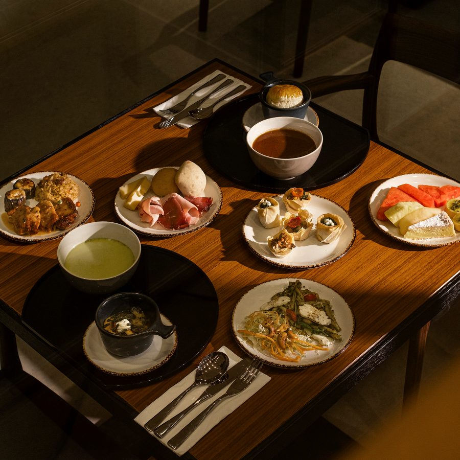 Dining table and chairs with multiple dishes on in The Bridge. 
