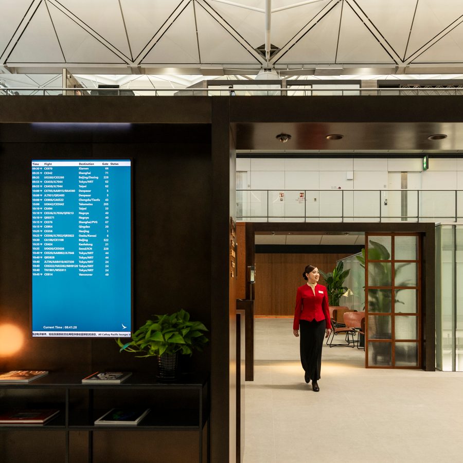 A Cathay Pacific staff member walking towards the entrance of The Bridge.