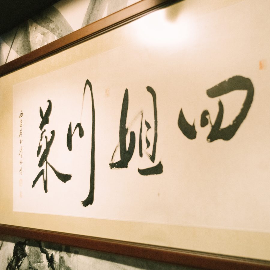 A framed ink calligraphy at the entrance of Sijie in Causeway Bay, Hong Kong.