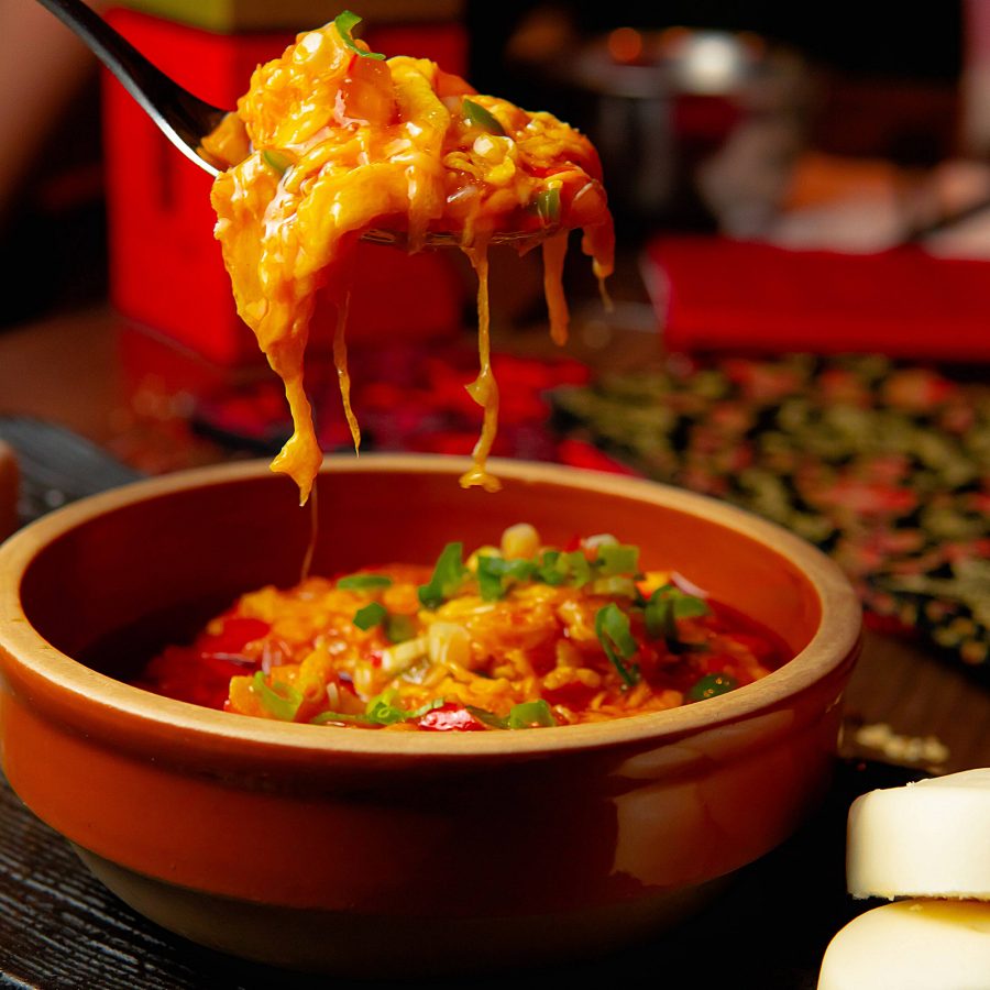 A closeup of a spoon holding up sichuan stirfried egg at Chili Fagara in Central, Hong Kong.