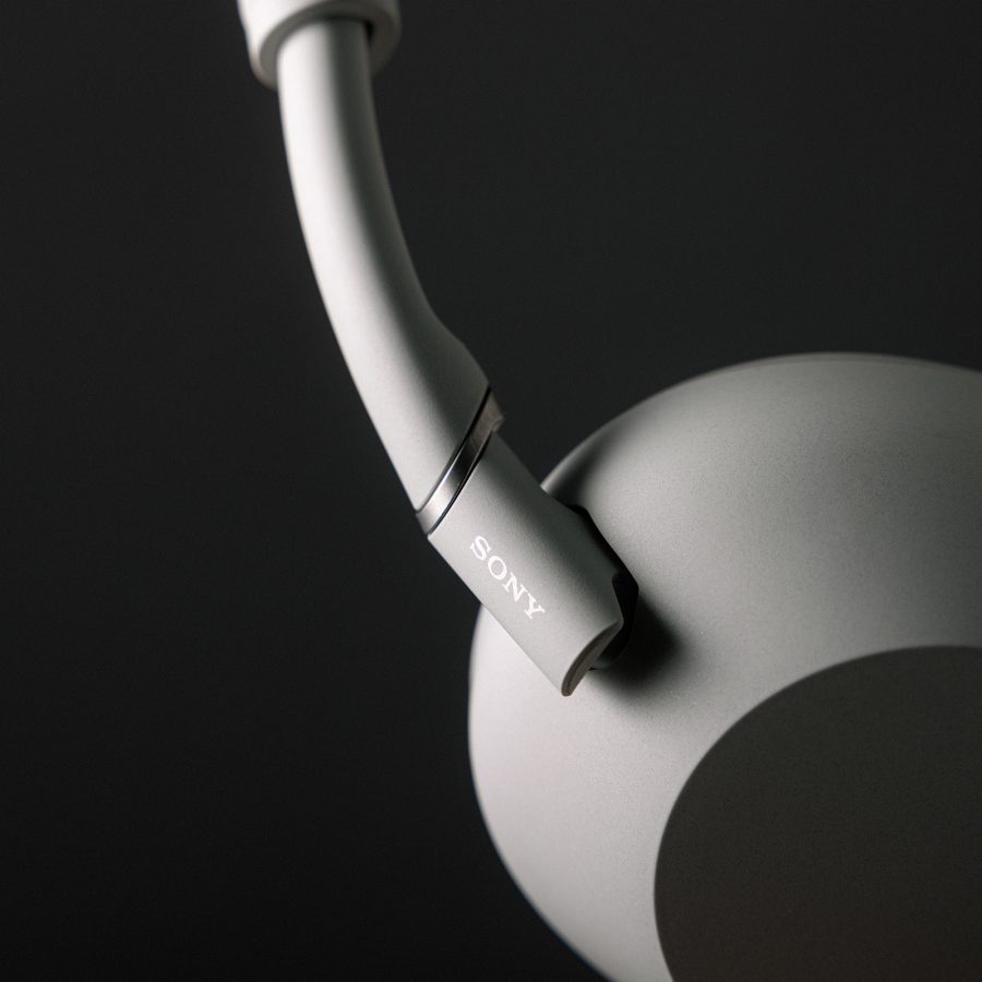 Close-up of the hinge and earcup on a pair of Sony WH-1000XM6 headphones in platinum silver. 