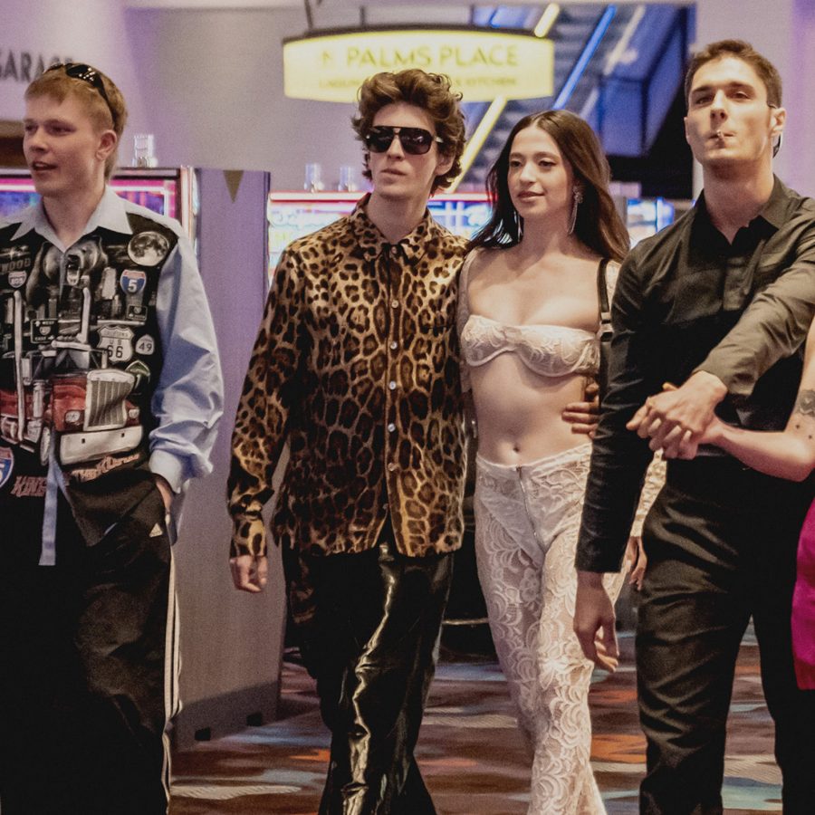 In a scene from Anora, six young men and women – including the titular Anora (Mikey Madison) – walk through a brightly lit casino, dressed in garish clothing. 